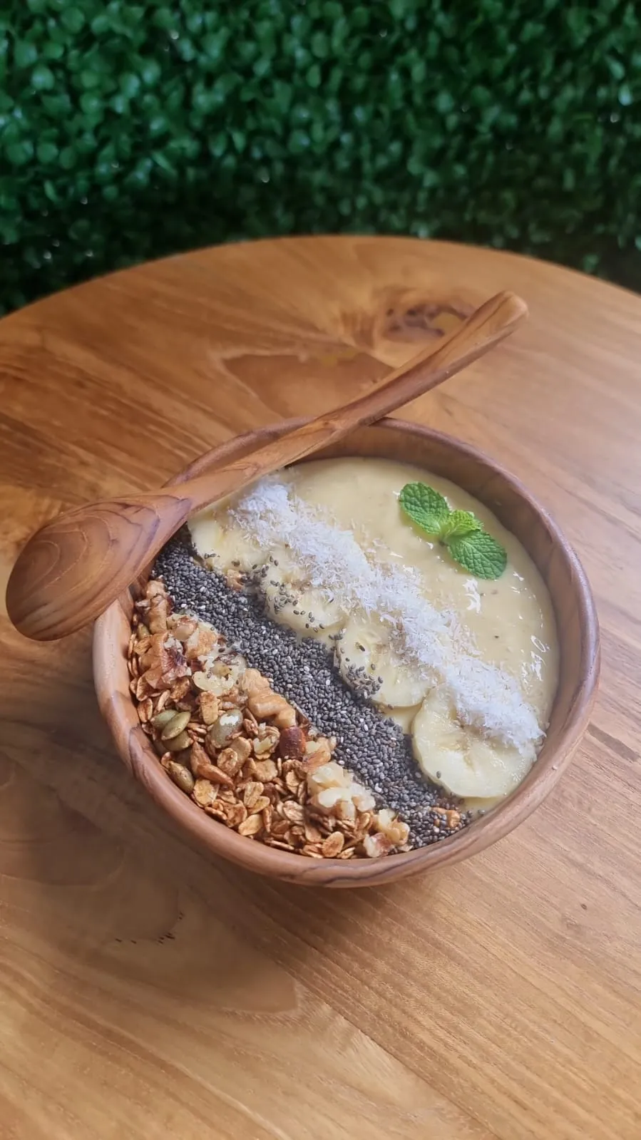 Smoothie bowl topped with banana, coconut flakes and granola