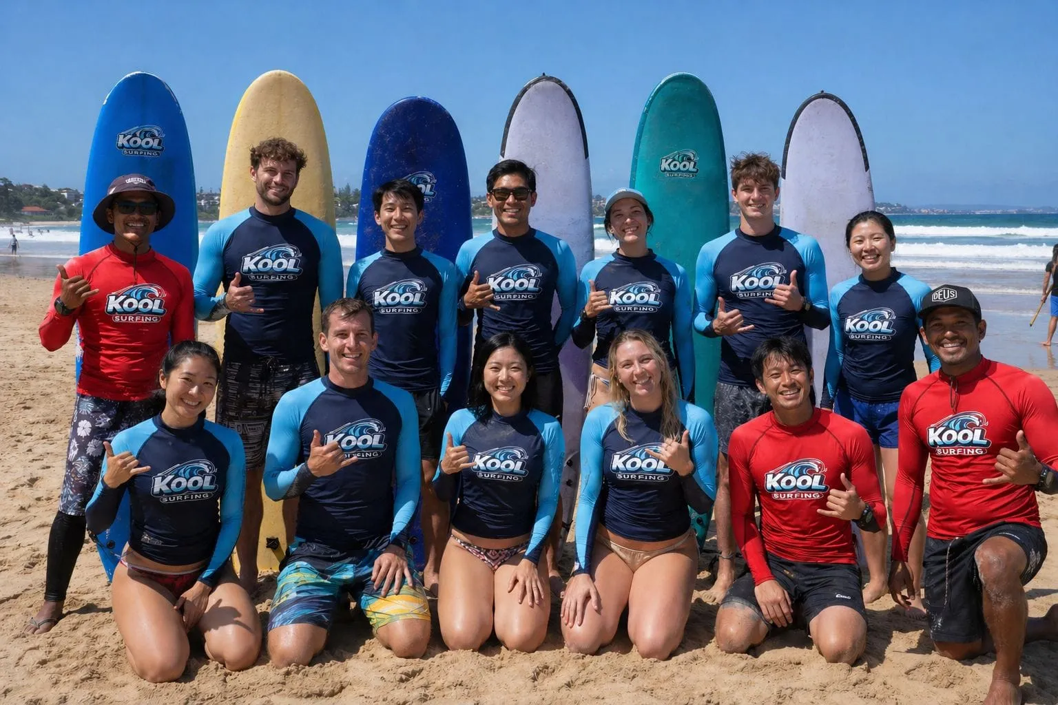 Kool Surf School instructors and students posing together on the beach in Kuta