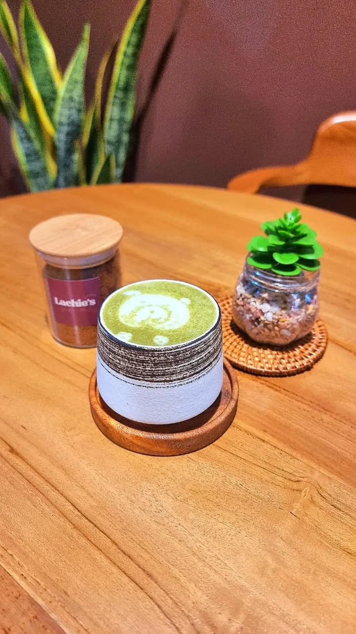 Matcha latte in a glass jar on a wooden table